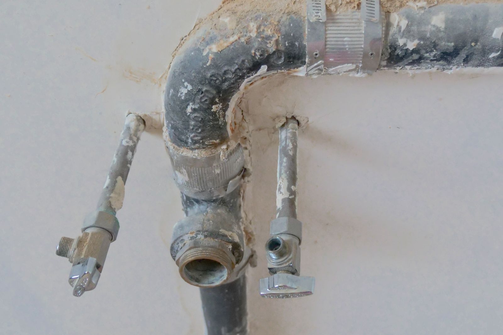 Old waste pipe and isolation valves exposed for repair