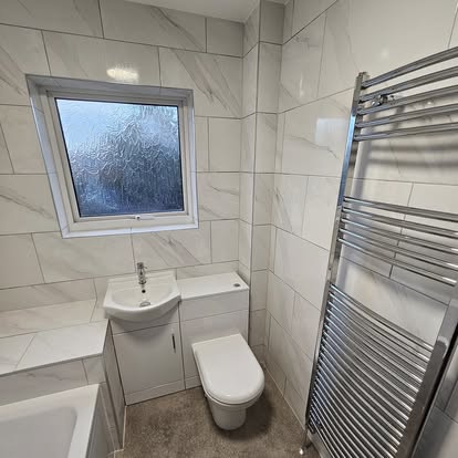 Refitted bathroom with basin unit, WC and chrome towel radiator