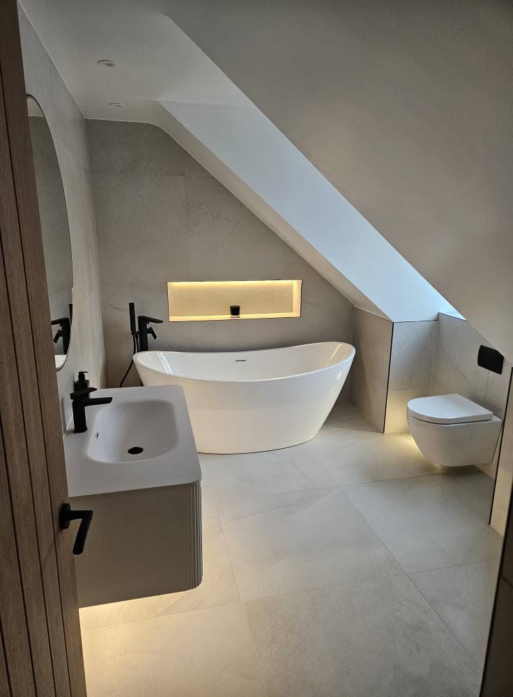 Completed loft en-suite with freestanding bath, floating vanity and wall-hung WC