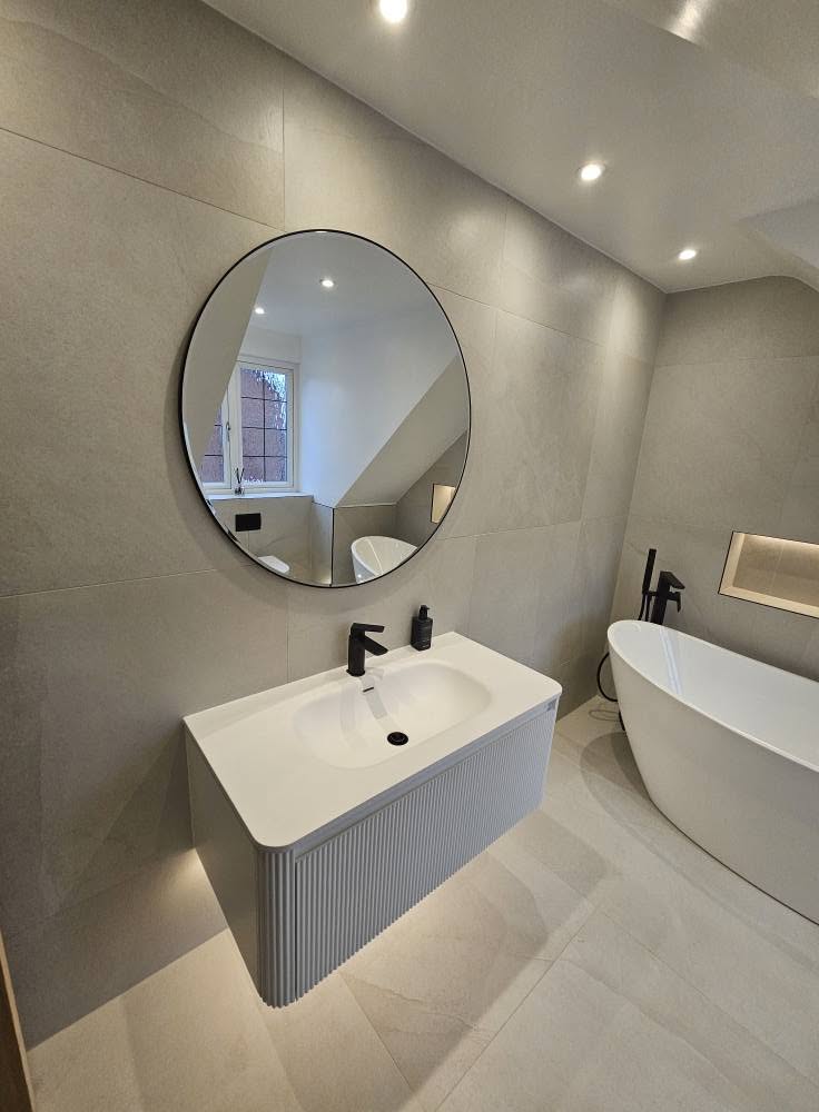 Floating fluted vanity unit with round mirror and matt black taps
