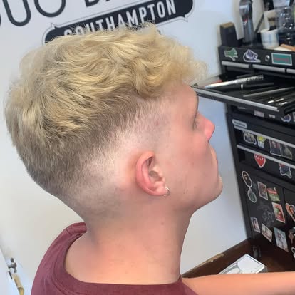 Blended skin fade with textured curly blonde top, finished at Duo Barbers
