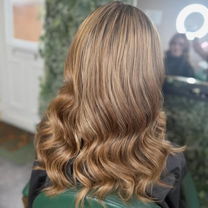 Bronde balayage colour blending brown and blonde tones, styled in waves