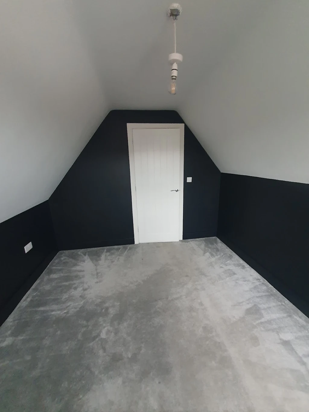 Navy-blue loft bedroom with white panelled door, finished decoration