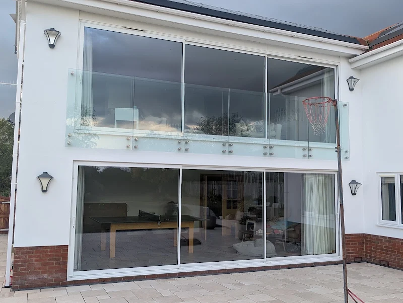 Freshly painted white render around large glazing on a house exterior