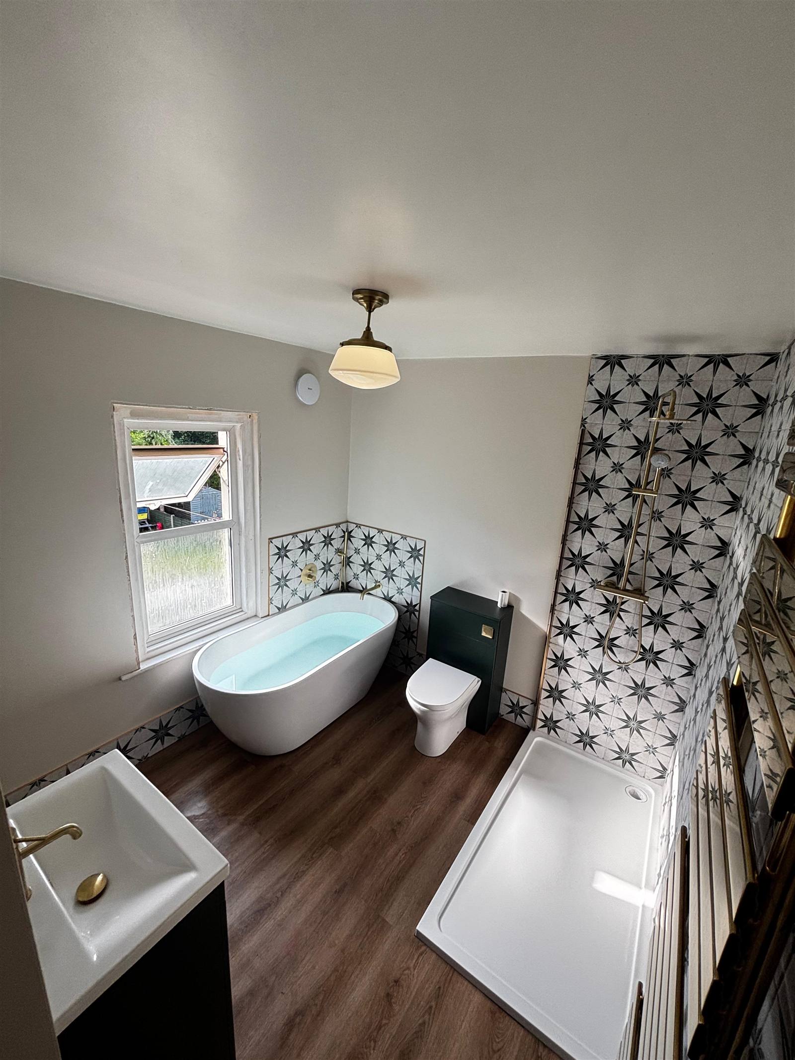 Renovated bathroom with freestanding bath and star pattern tiles