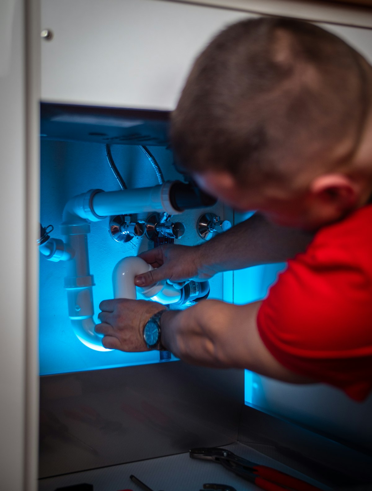 Gas engineer working on pipework beneath a unit