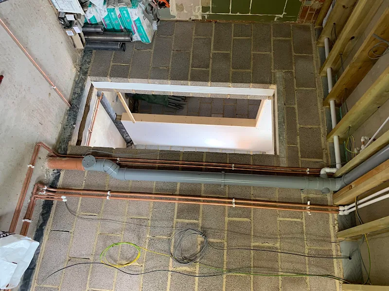 First-fix copper and waste pipework laid across a beam-and-block floor on a new build