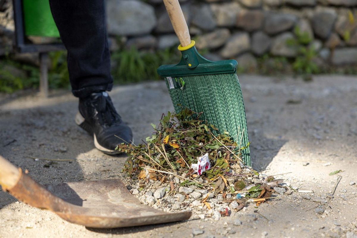 Raking up leaves and garden debris during a clearance