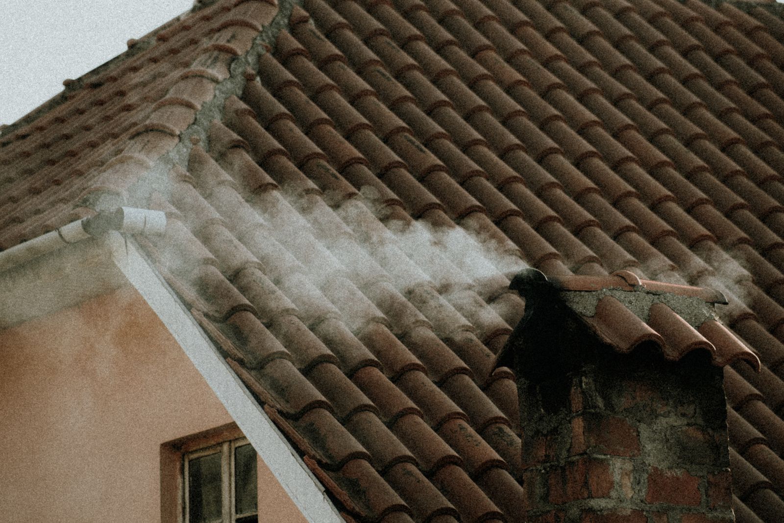 Brick chimney on a tiled roof