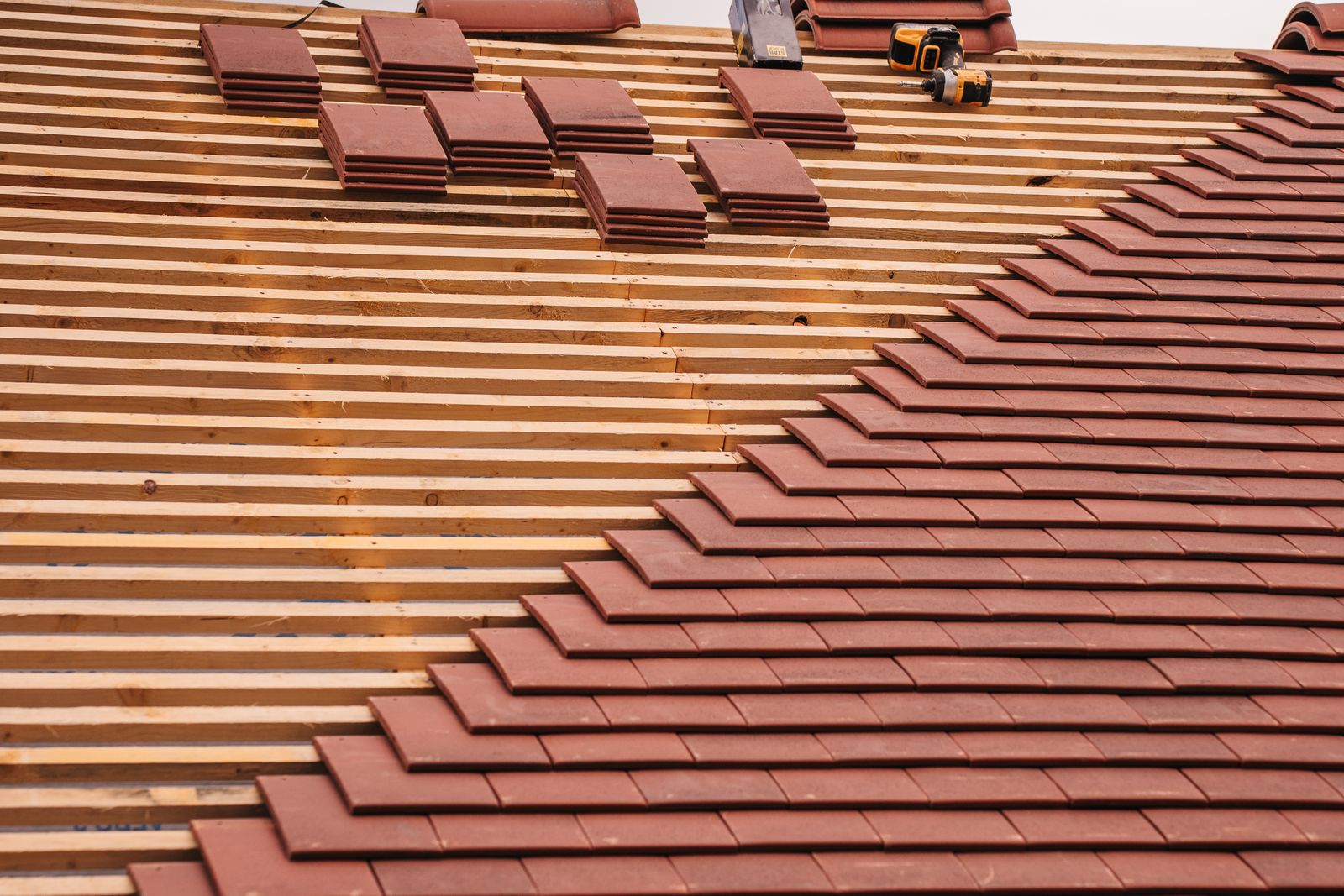 New clay roof tiles being fixed to timber battens