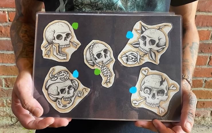 Hand-painted flash sheet of skull designs, part of the Tattoo Magic Southampton studio