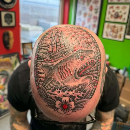 Blackwork shark and shipwreck scalp tattoo with red ink accents, custom design by Tattoo Magic Southampton