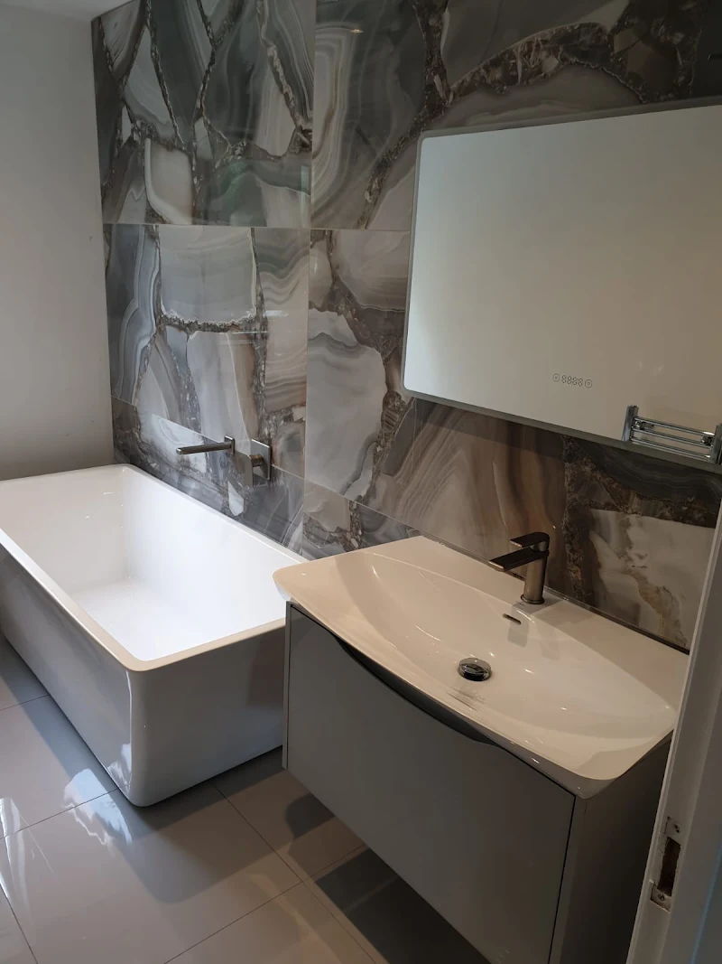 Bathroom with marble-effect feature wall, bath and floating vanity unit