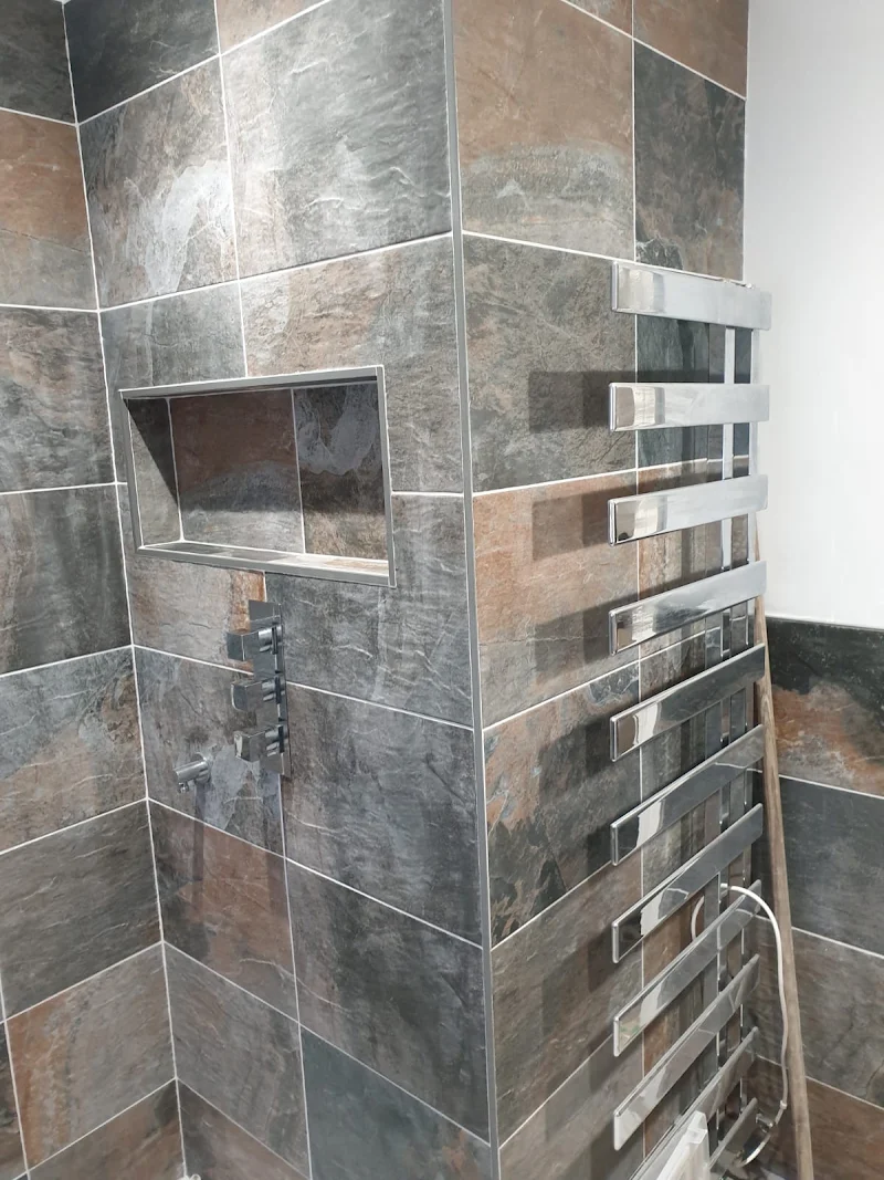 Slate-tiled shower with recessed niche and chrome towel radiator