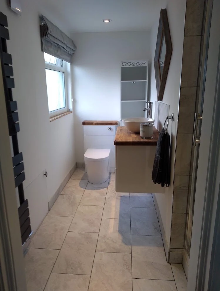 Refitted bathroom with wall-hung toilet, floating vanity and tiled floor