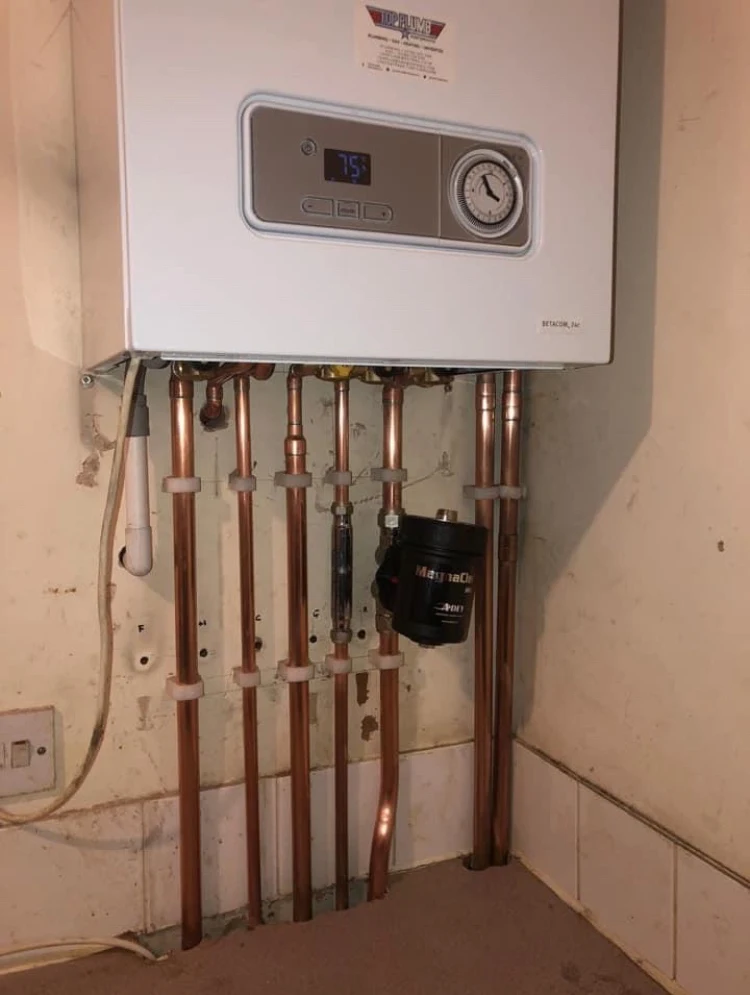 New boiler installed with neatly clipped copper pipework and magnetic system filter