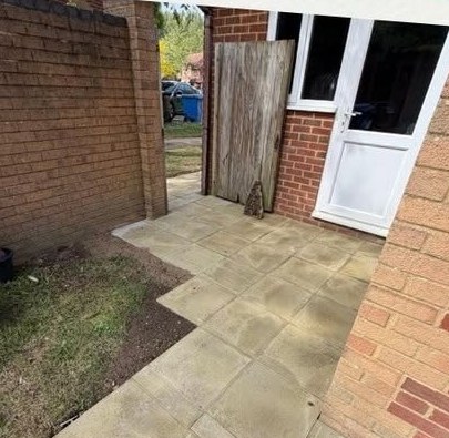 Paved patio area laid up to the property's rear entrance