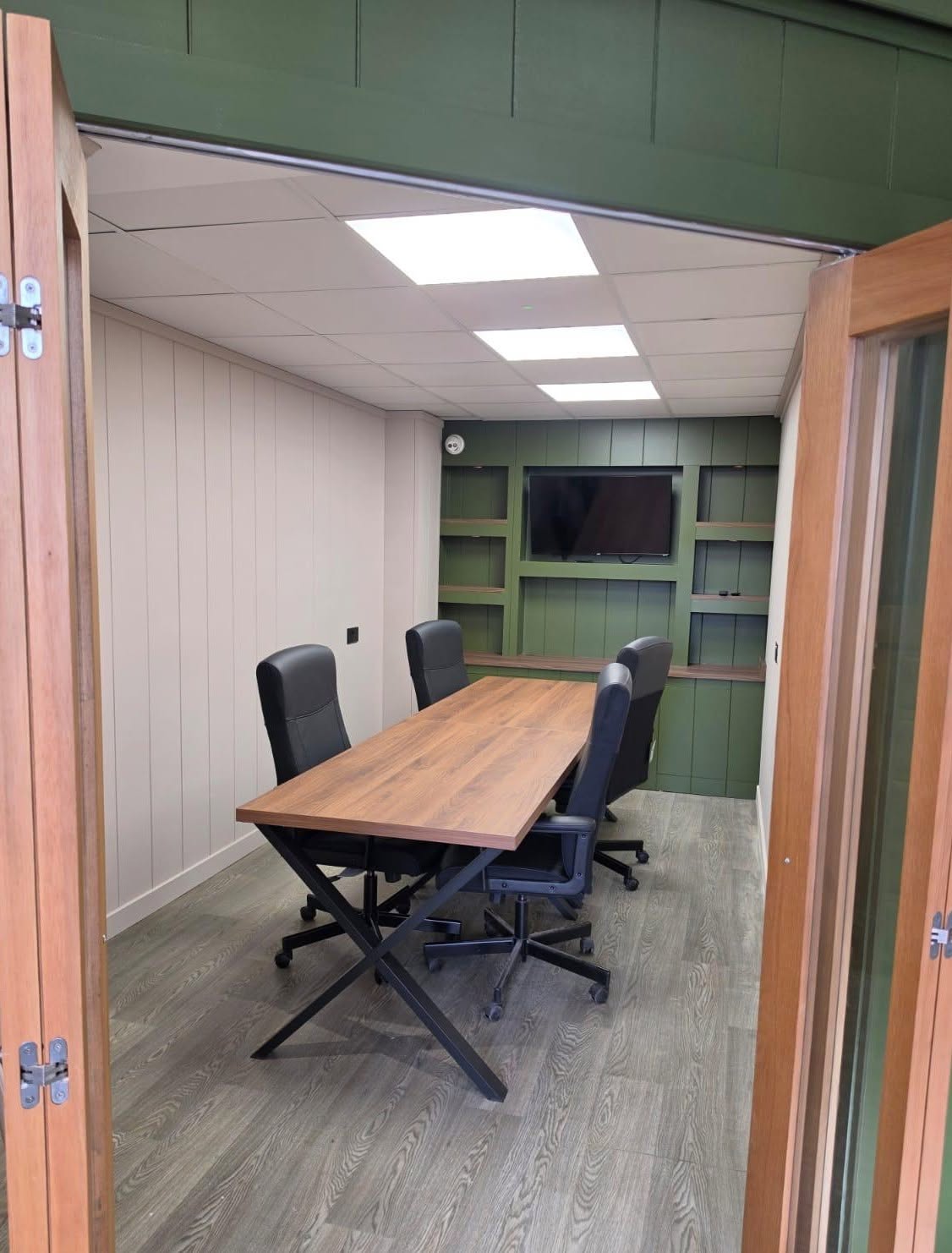 Meeting room fit-out seen through oak bi-fold doors