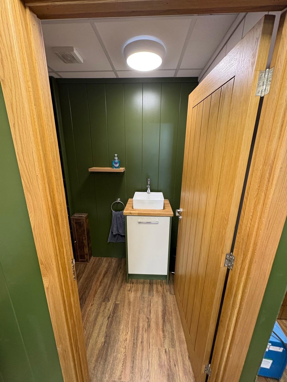 Commercial washroom with oak doors and green panelling